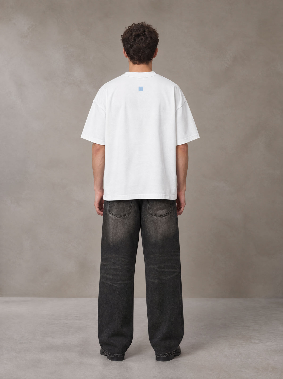 Model wearing the SM Baroque Bloom T-shirt in Lucent White, rear view.