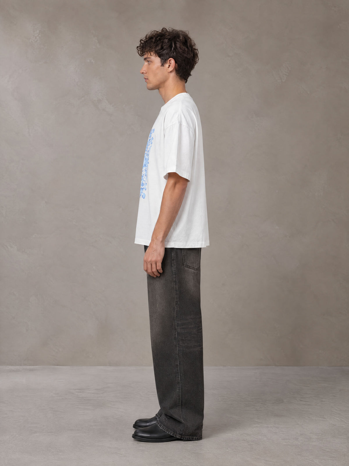 Model wearing the SM Baroque Bloom T-shirt in Lucent White, side profile.