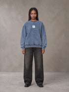 Model wearing the SM Denim Wash Sweatshirt in Chambray, front view.