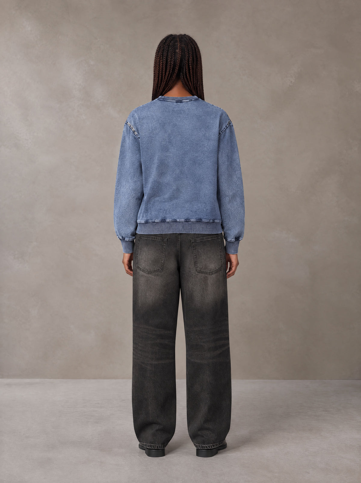 Model wearing the SM Denim Wash Sweatshirt in Chambray, rear view.