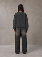 Model wearing the SM Denim Wash Sweatshirt in Midnight Black, rear view.