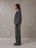 Model wearing the SM Denim Wash Sweatshirt in Midnight Black, side profile.