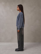 Model wearing the SM Denim Wash Sweatshirt in Oxford Navy, side profile.