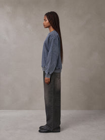 Model wearing the SM Denim Wash Sweatshirt in Oxford Navy, side profile.