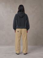 Model wearing the SM Eternal Fleur Belted Trousers in Camel Tan, rear view.