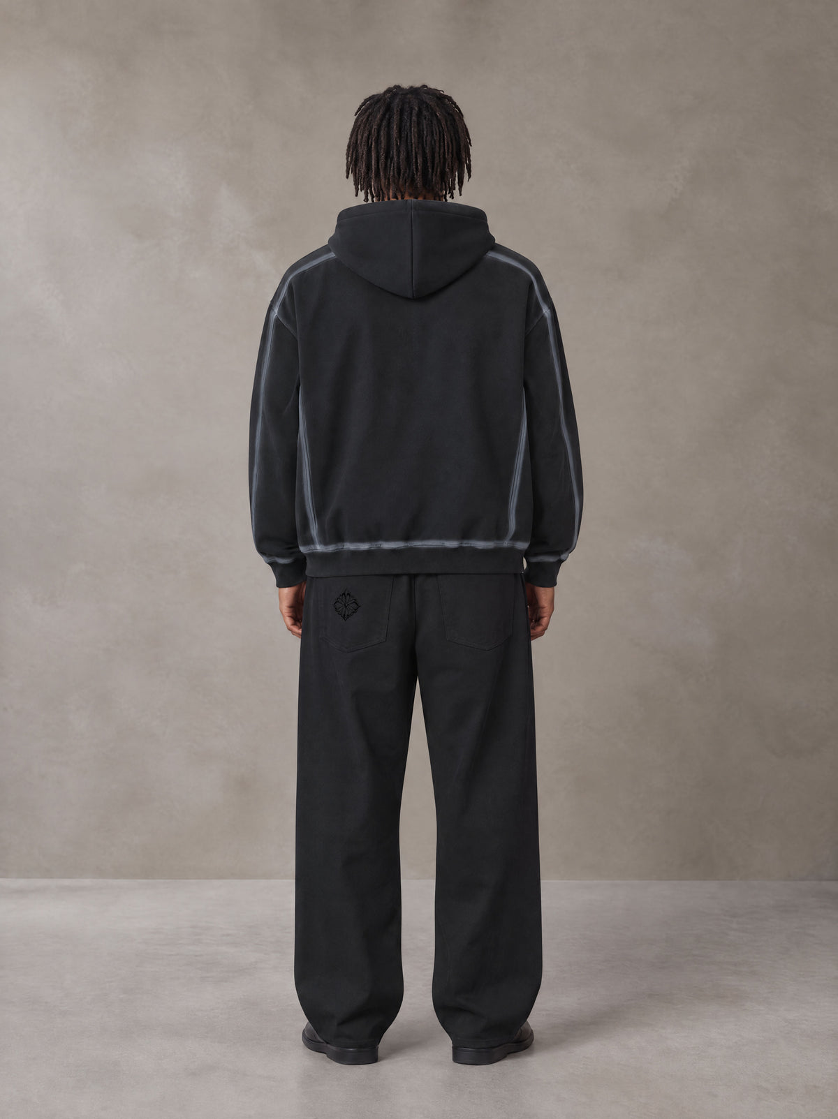 Model wearing the SM Eternal Fleur Belted Trousers in Midnight Black, rear view.