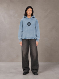 Model wearing the SM Eternal Fleur Hoodie in Washed Blue Jean, front view.