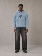 Model wearing the SM Eternal Fleur Hoodie in Washed Blue Jean, front view.