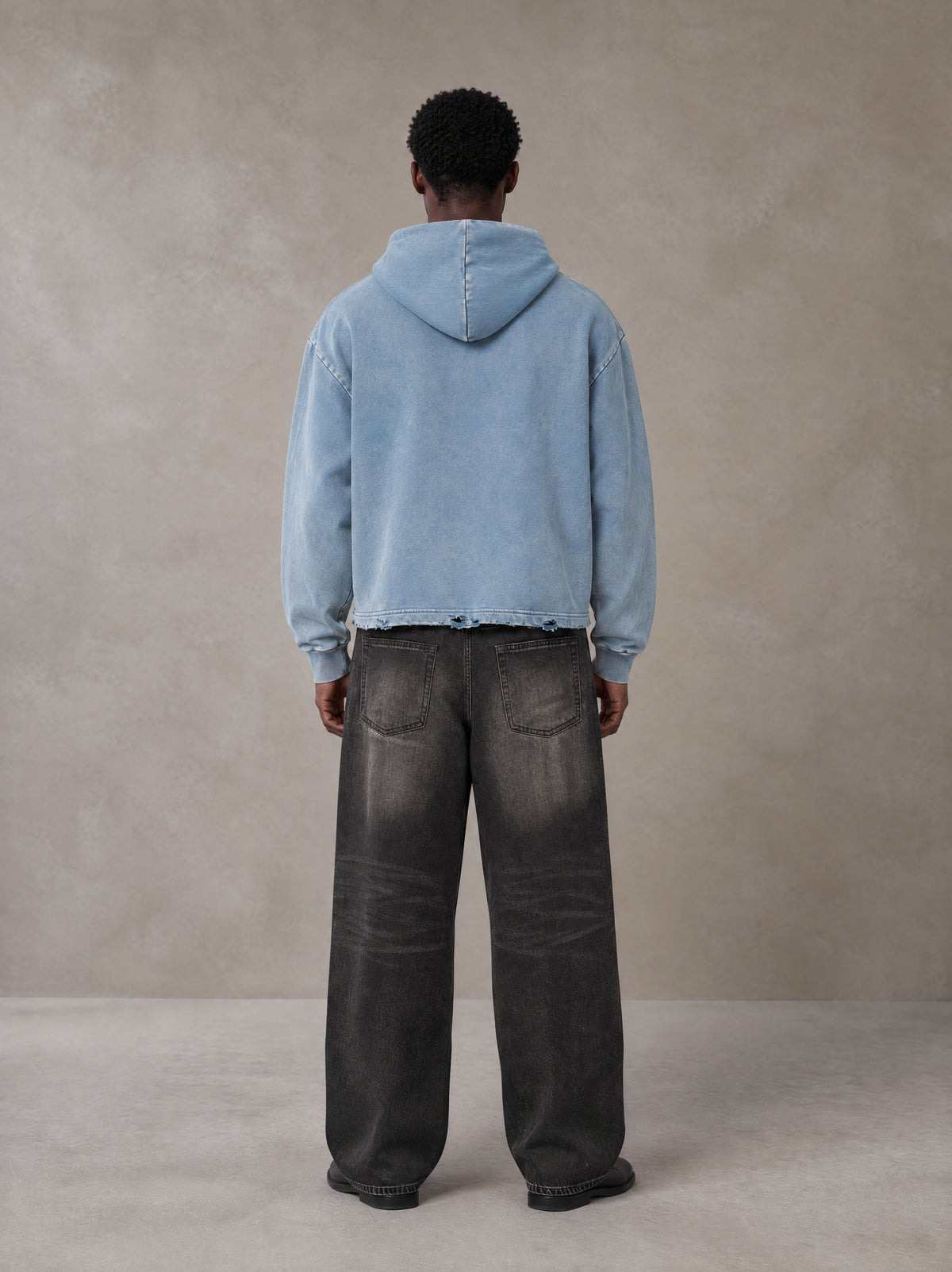 Model wearing the SM Eternal Fleur Hoodie in Washed Blue Jean, rear view.
