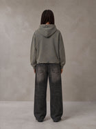 Model wearing the SM Eternal Fleur Hoodie in Stone Grey, rear view.