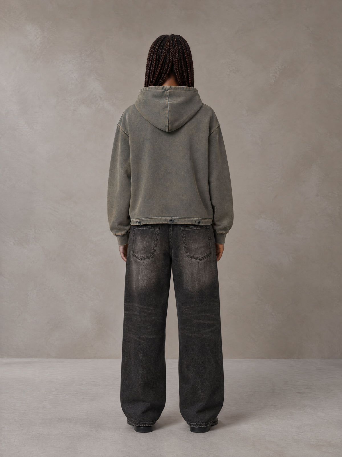 Model wearing the SM Eternal Fleur Hoodie in Stone Grey, rear view.