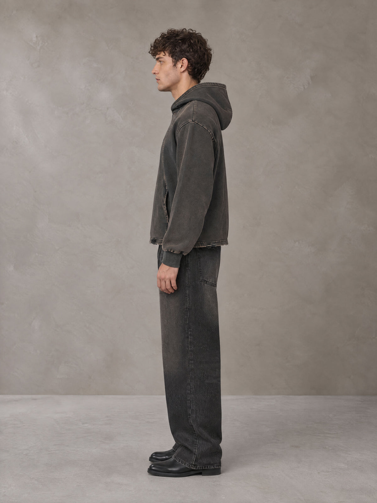 Model wearing the SM Eternal Fleur Hoodie in Deep Charcoal, side profile.