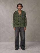 Model wearing the SM Abstract Jacquard Knitted Cardigan in Olive Shade, front view.