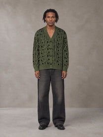 Model wearing the SM Abstract Jacquard Knitted Cardigan in Olive Shade, front view.