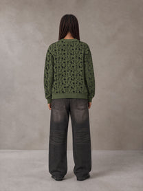 Model wearing the SM Abstract Jacquard Knitted Cardigan in Olive Shade, rear view.