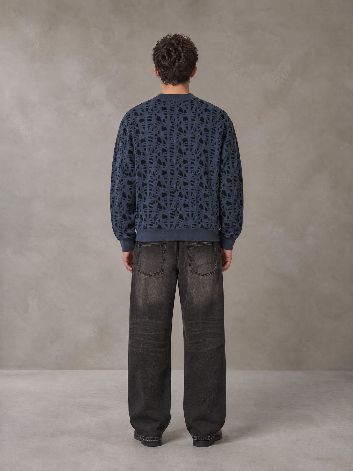Model wearing the SM Abstract Jacquard Knitted Cardigan in Oxford Navy, rear view.