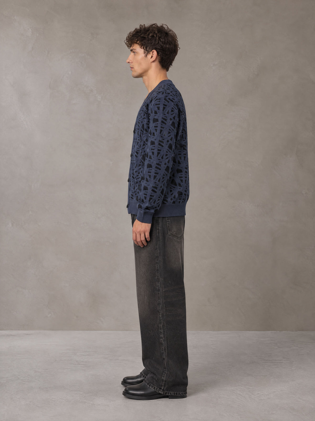 Model wearing the SM Abstract Jacquard Knitted Cardigan in Oxford Navy, side profile.