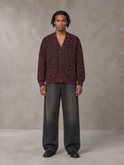 Model wearing the SM Abstract Jacquard Knitted Cardigan in Burgundy, front view.