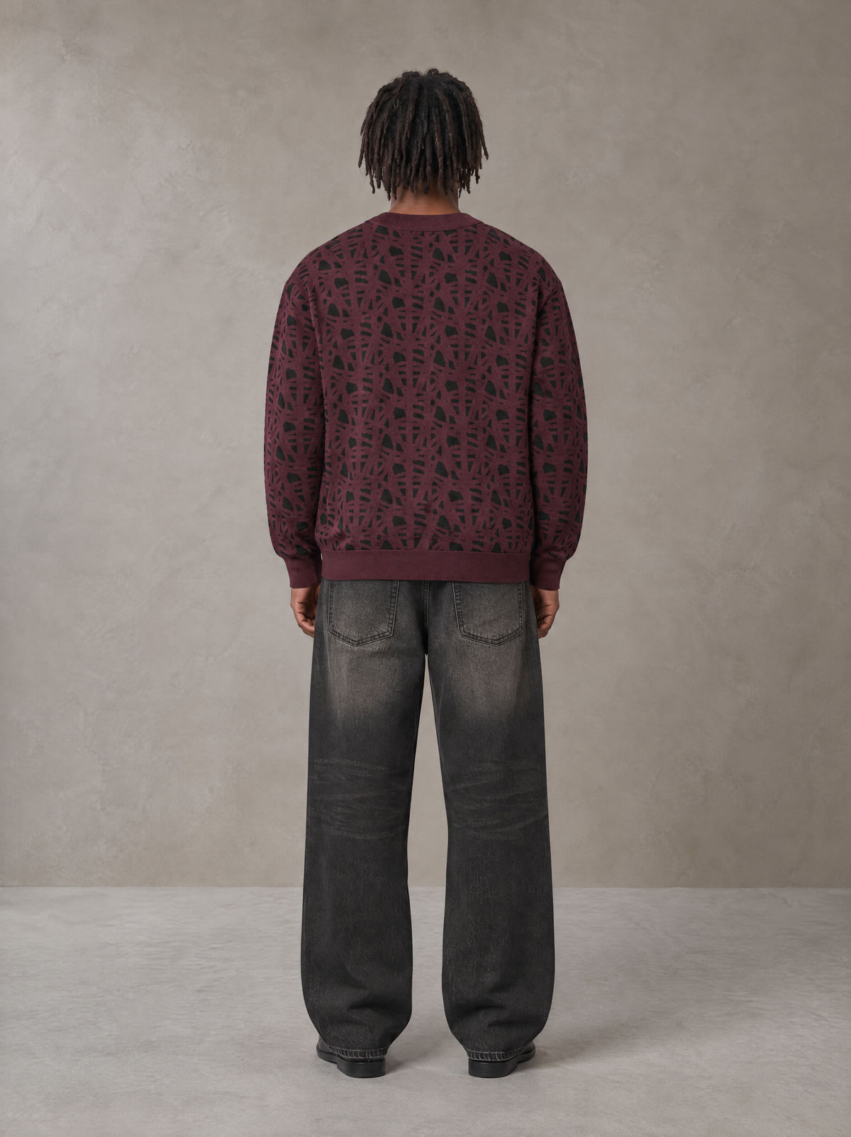 Model wearing the SM Abstract Jacquard Knitted Cardigan in Burgundy, rear view.
