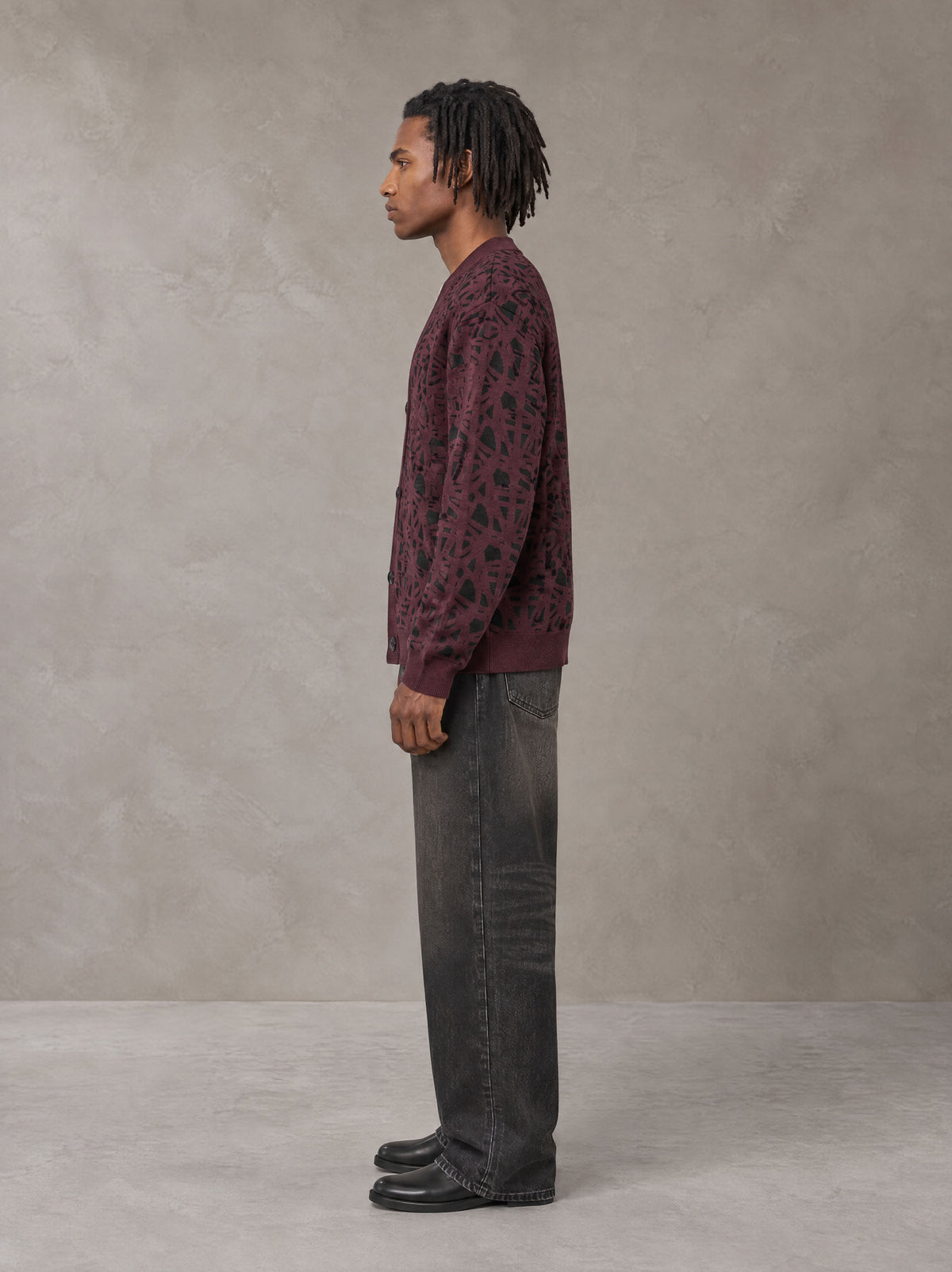 Model wearing the SM Abstract Jacquard Knitted Cardigan in Burgundy, side profile.