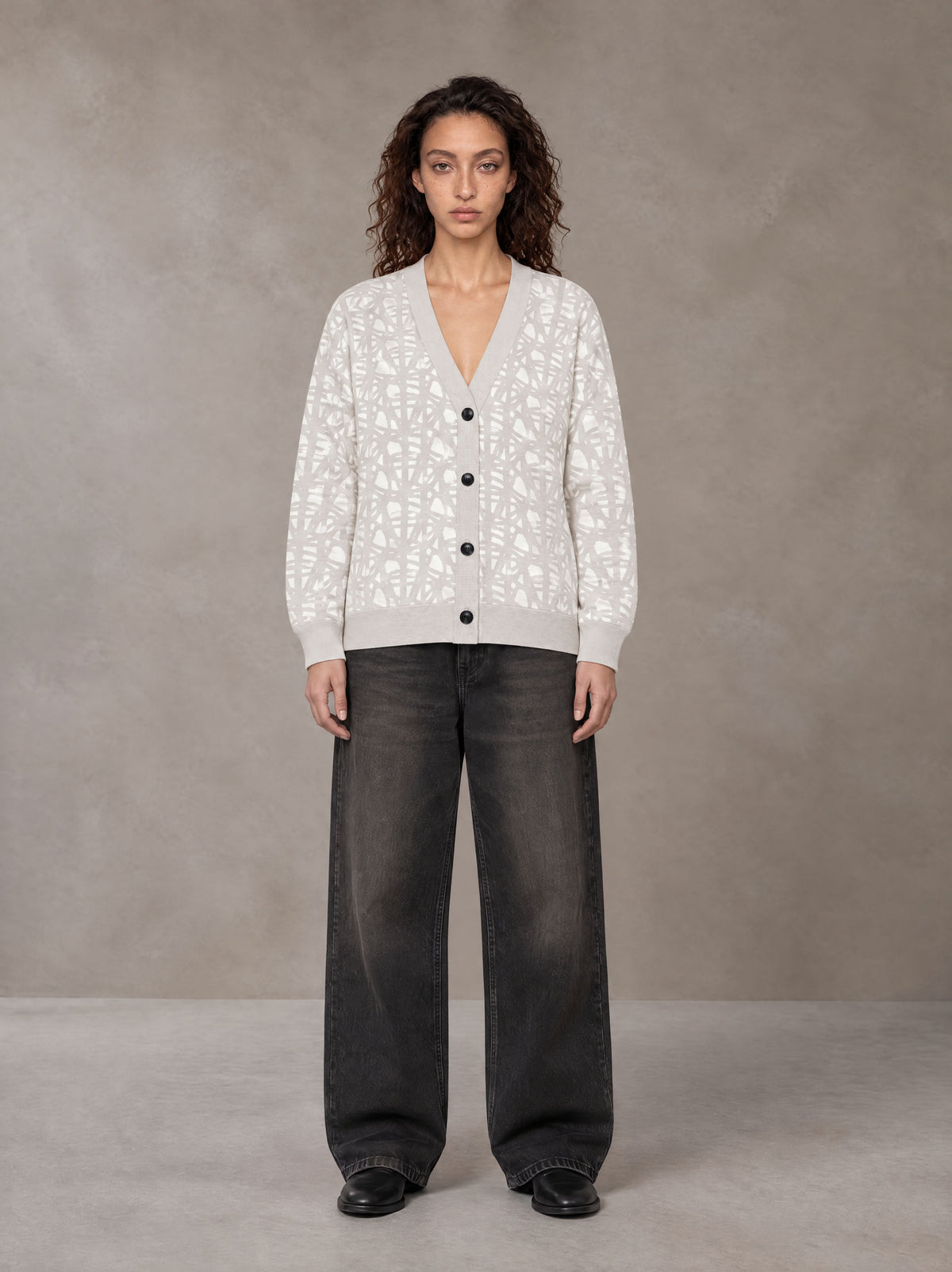 Model wearing the SM Abstract Jacquard Knitted Cardigan in Ivory White, front view.