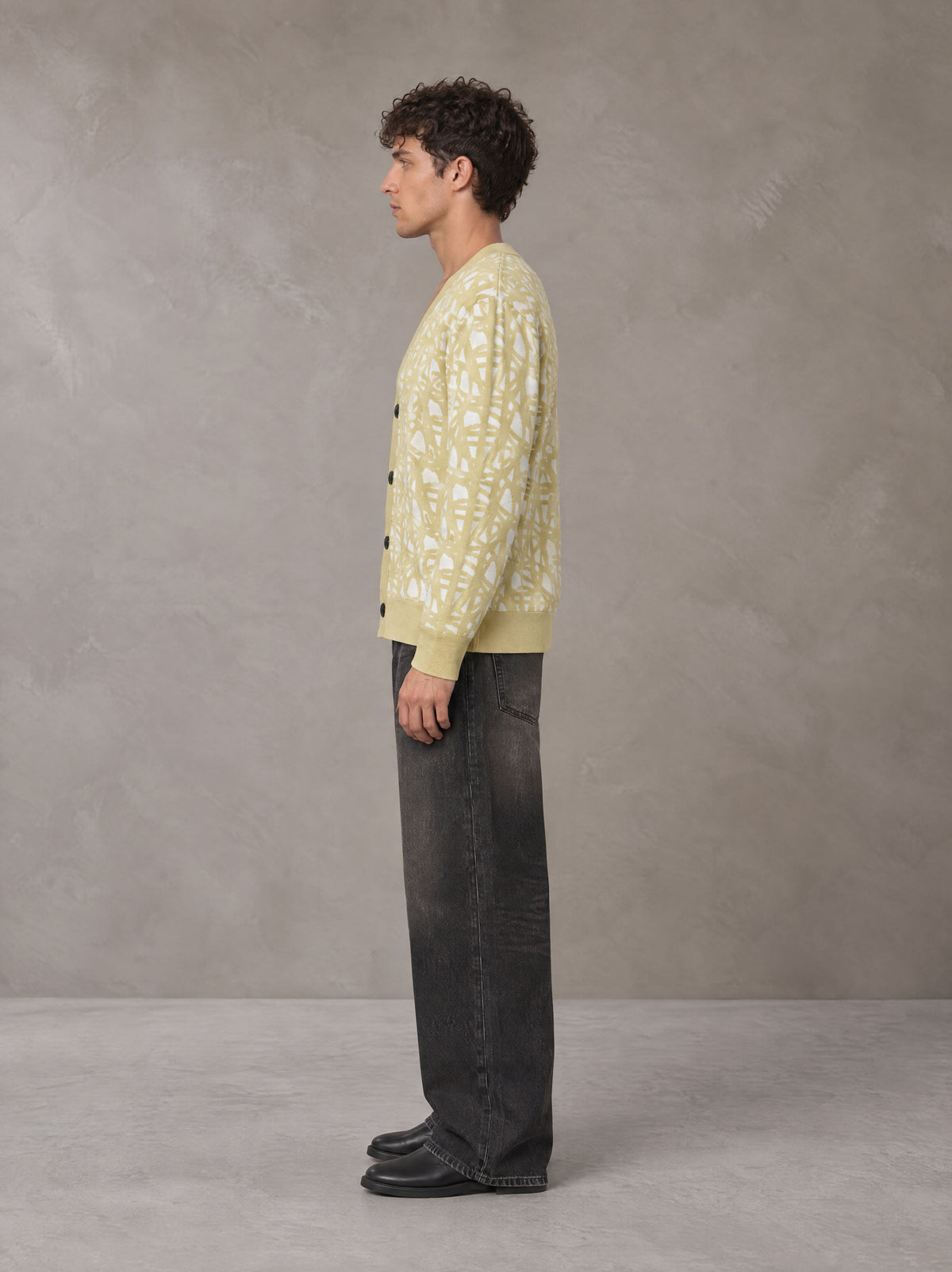 Model wearing the SM Abstract Jacquard Knitted Cardigan in Natural Flax, side profile.