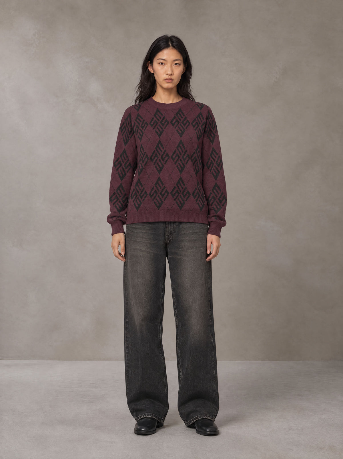 Model wearing the SM Argyle Jacquard Knitted Sweatshirt in Burgundy, front view.