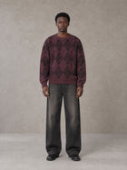 Model wearing the SM Argyle Jacquard Knitted Sweatshirt in Burgundy, front view.