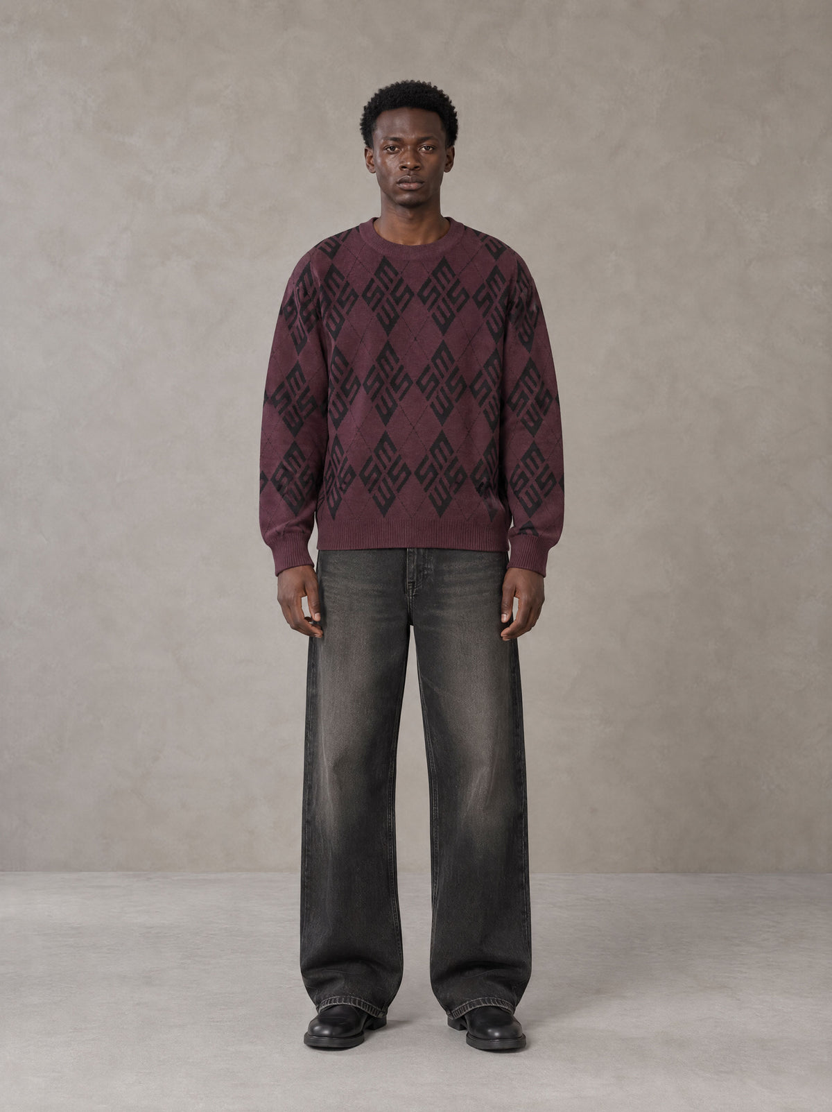 Model wearing the SM Argyle Jacquard Knitted Sweatshirt in Burgundy, front view.