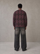 Model wearing the SM Argyle Jacquard Knitted Sweatshirt in Burgundy, rear view.