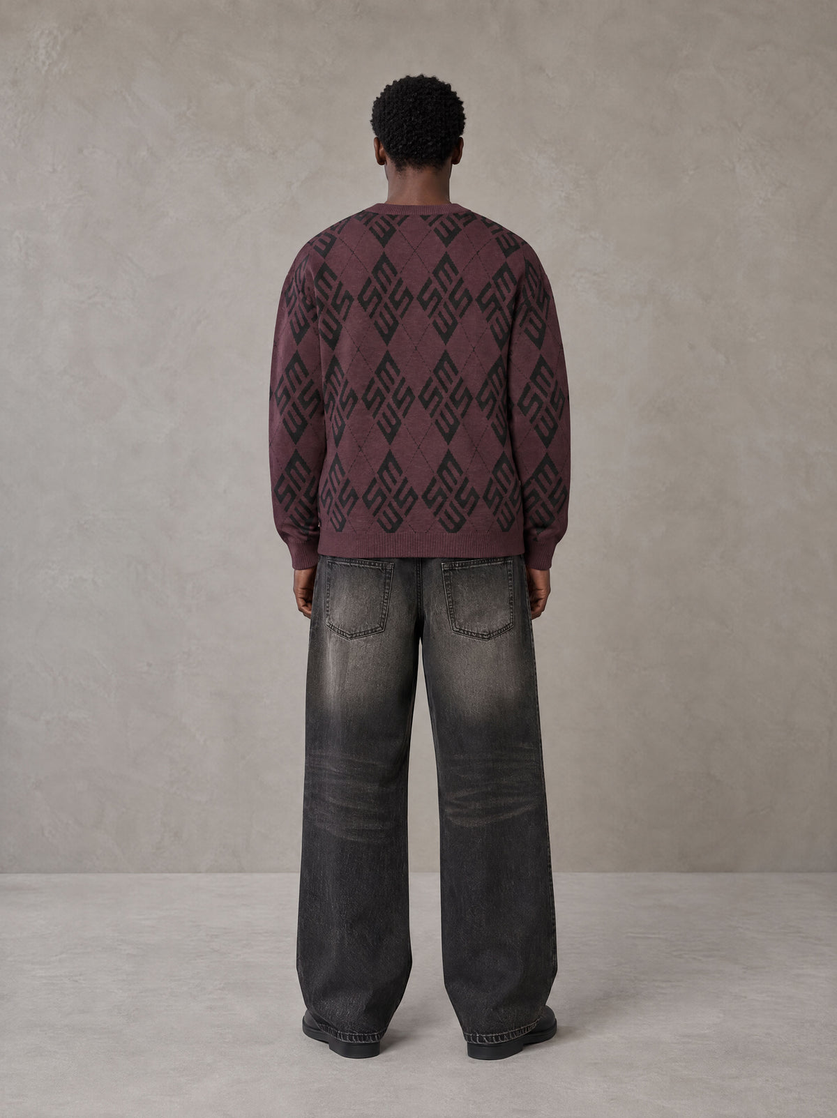 Model wearing the SM Argyle Jacquard Knitted Sweatshirt in Burgundy, rear view.