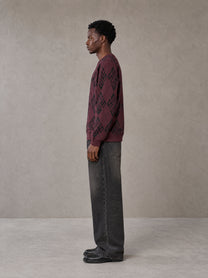 Model wearing the SM Argyle Jacquard Knitted Sweatshirt in Burgundy, side profile.