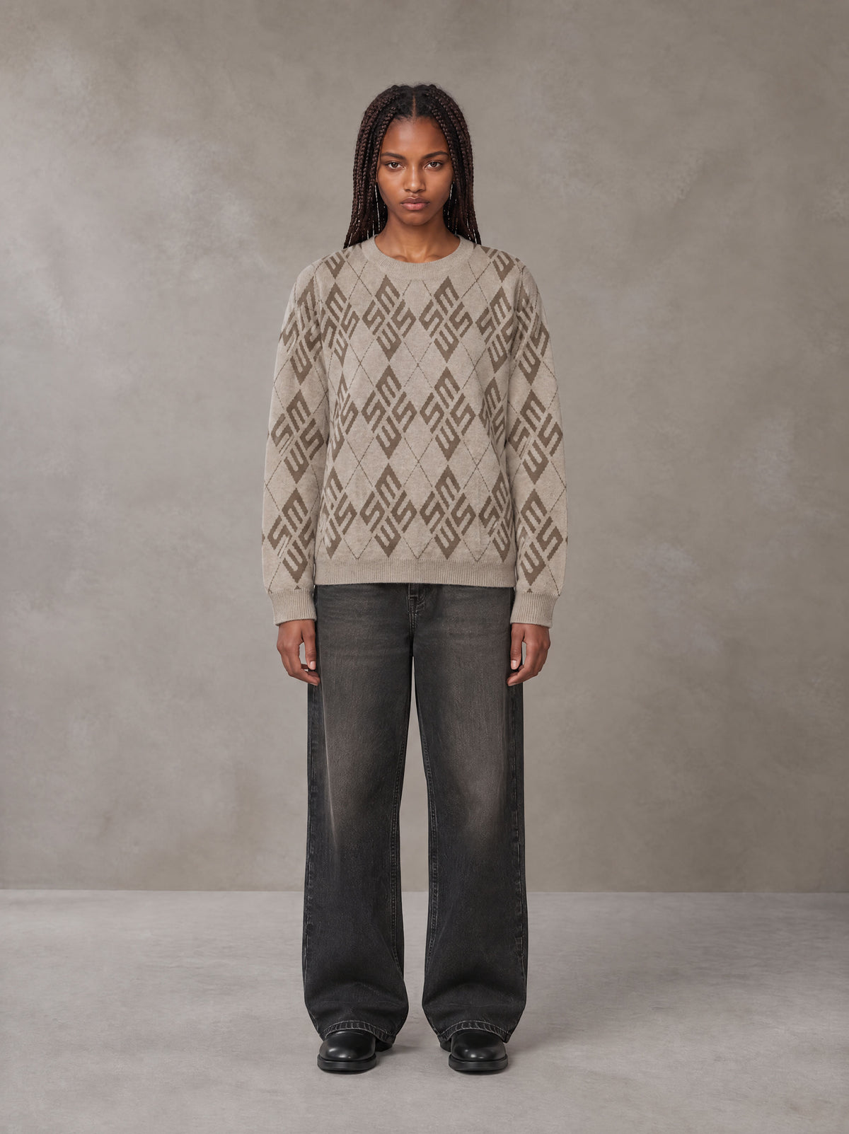 Model wearing the SM Argyle Jacquard Knitted Sweatshirt in Fine Sand, front view.