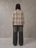 Model wearing the SM Argyle Jacquard Knitted Sweatshirt in Fine Sand, rear view.