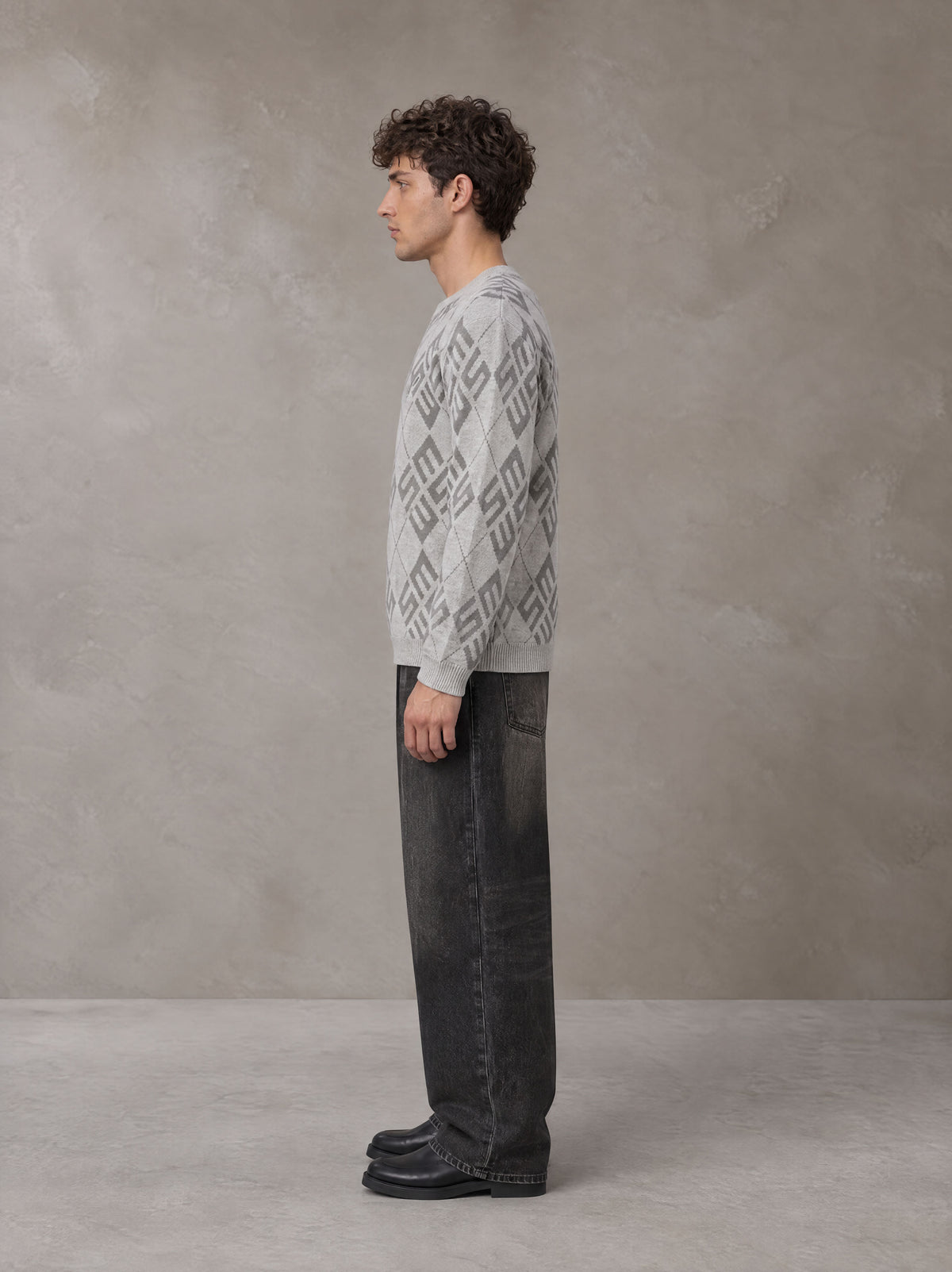 Model wearing the SM Argyle Jacquard Knitted Sweatshirt in Polished Silver, side profile.