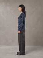 Model wearing the SM Argyle Jacquard Knitted Sweatshirt in Oxford Navy, side profile.