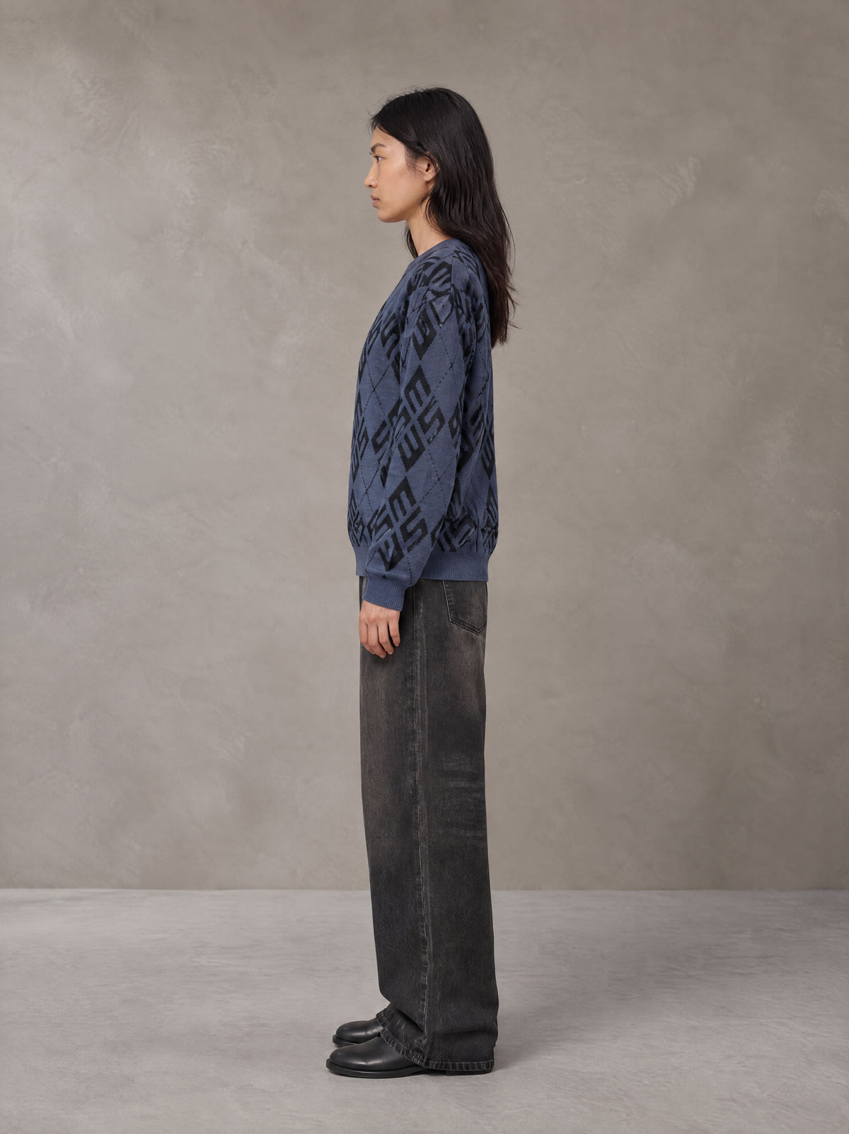 Model wearing the SM Argyle Jacquard Knitted Sweatshirt in Oxford Navy, side profile.