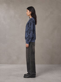 Model wearing the SM Argyle Jacquard Knitted Sweatshirt in Oxford Navy, side profile.