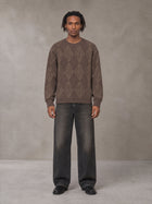 Model wearing the SM Argyle Jacquard Knitted Sweatshirt in Deep Coffee, front view.
