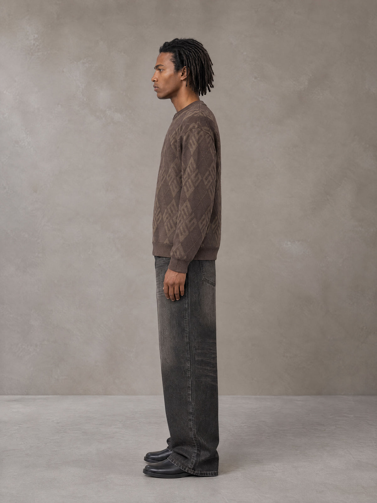 Model wearing the SM Argyle Jacquard Knitted Sweatshirt in Deep Coffee, side profile.