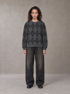 Model wearing the SM Argyle Jacquard Knitted Sweatshirt in Deep Charcoal, front view.