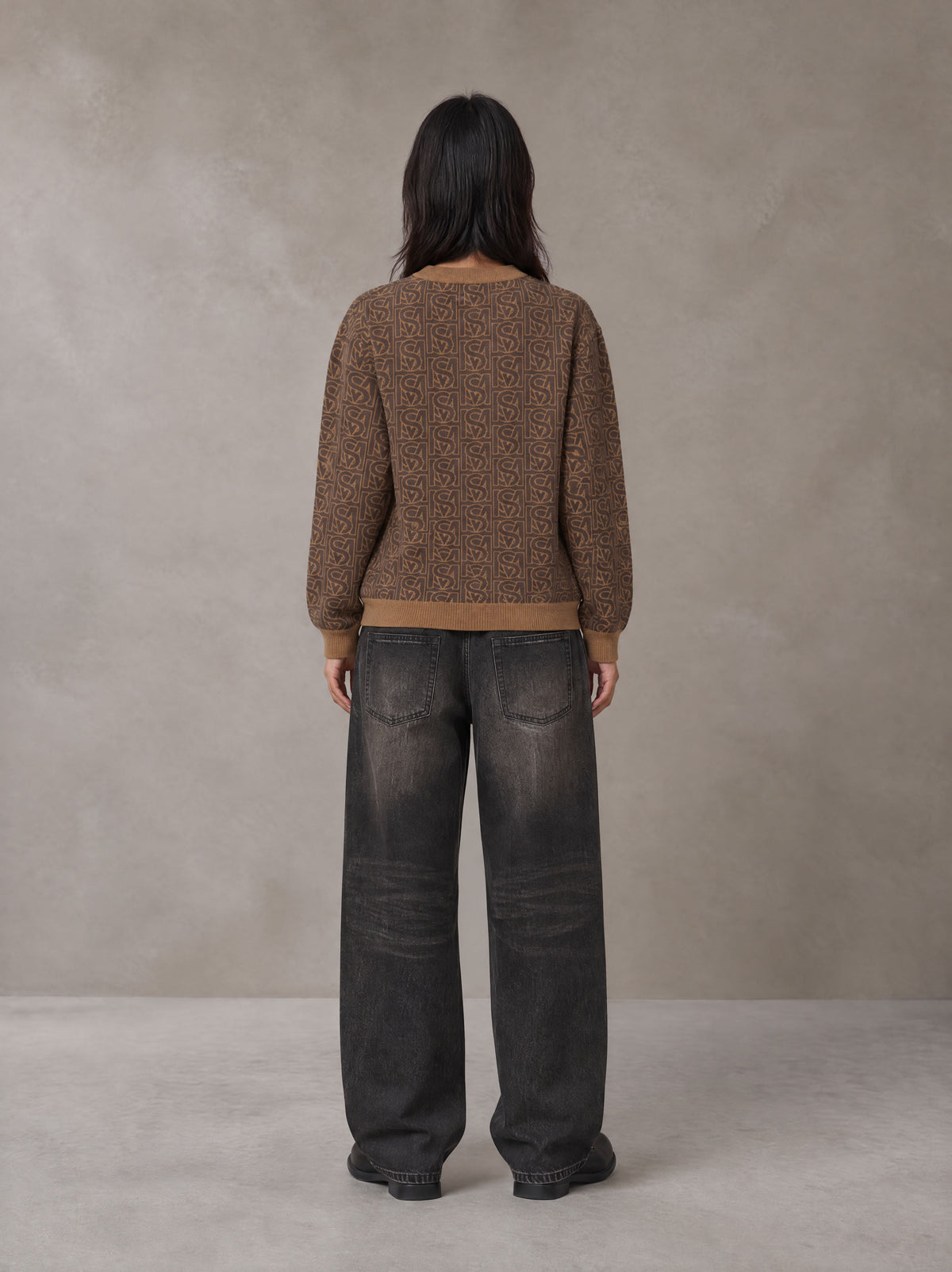 Model wearing the SM Jacquard Knitted Sweatshirt in Brown, rear view.