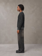 Model wearing the SM Jacquard Knitted Sweatshirt in Midnight Black, side profile.