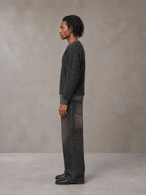 Model wearing the SM Jacquard Knitted Sweatshirt in Midnight Black, side profile.