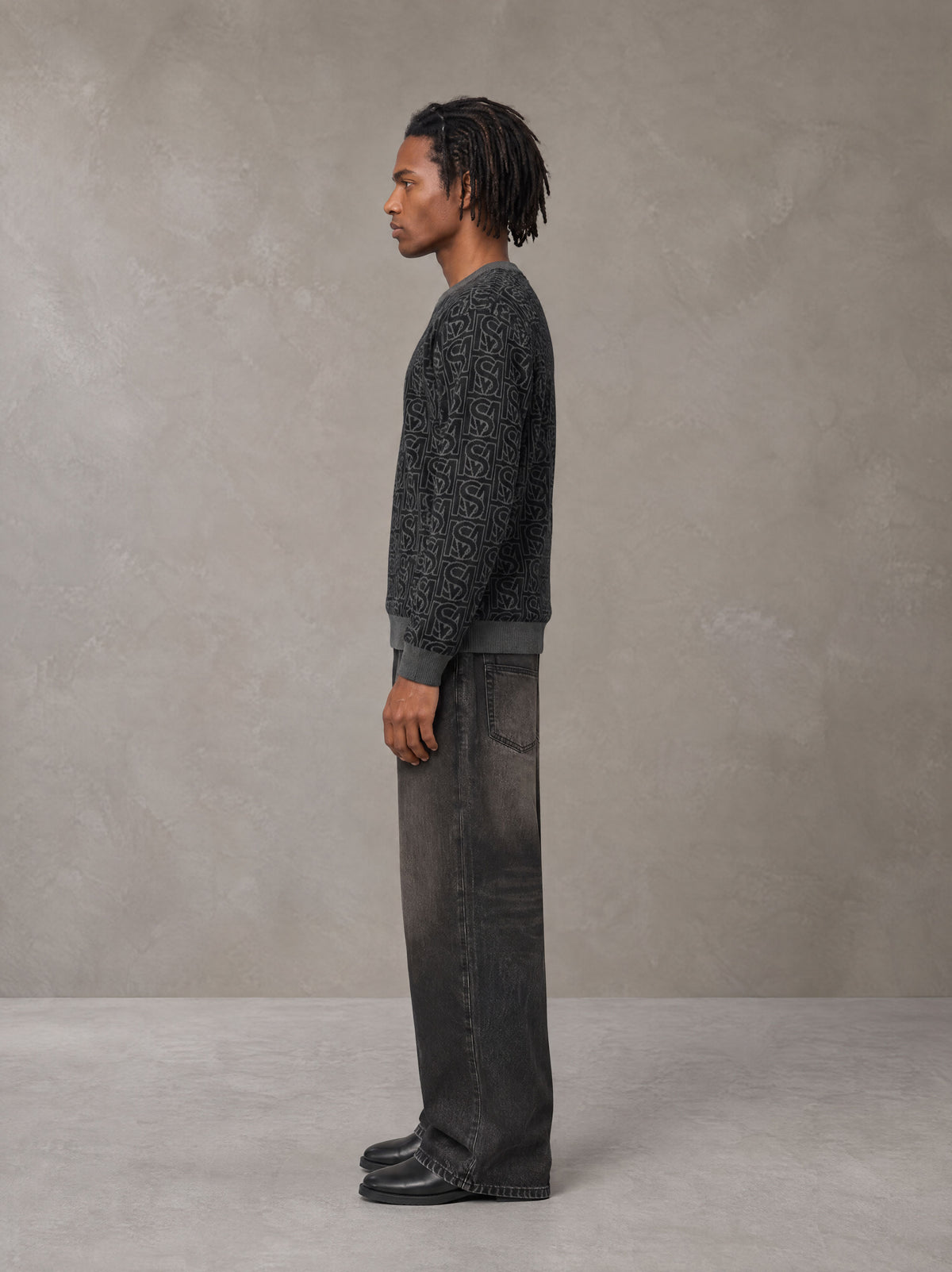 Model wearing the SM Jacquard Knitted Sweatshirt in Midnight Black, side profile.