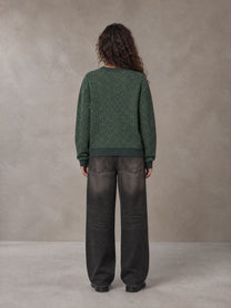 Model wearing the SM Jacquard Knitted Sweatshirt in Dark Green, rear view.