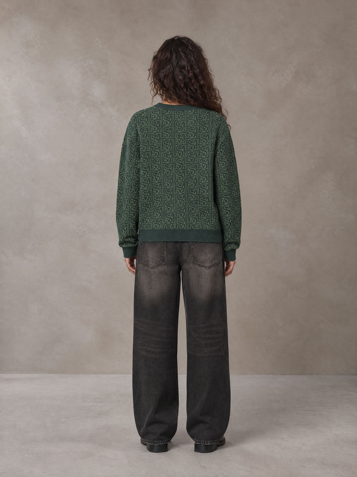 Model wearing the SM Jacquard Knitted Sweatshirt in Dark Green, rear view.