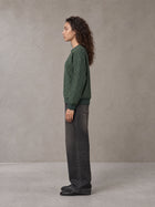 Model wearing the SM Jacquard Knitted Sweatshirt in Dark Green, side profile.