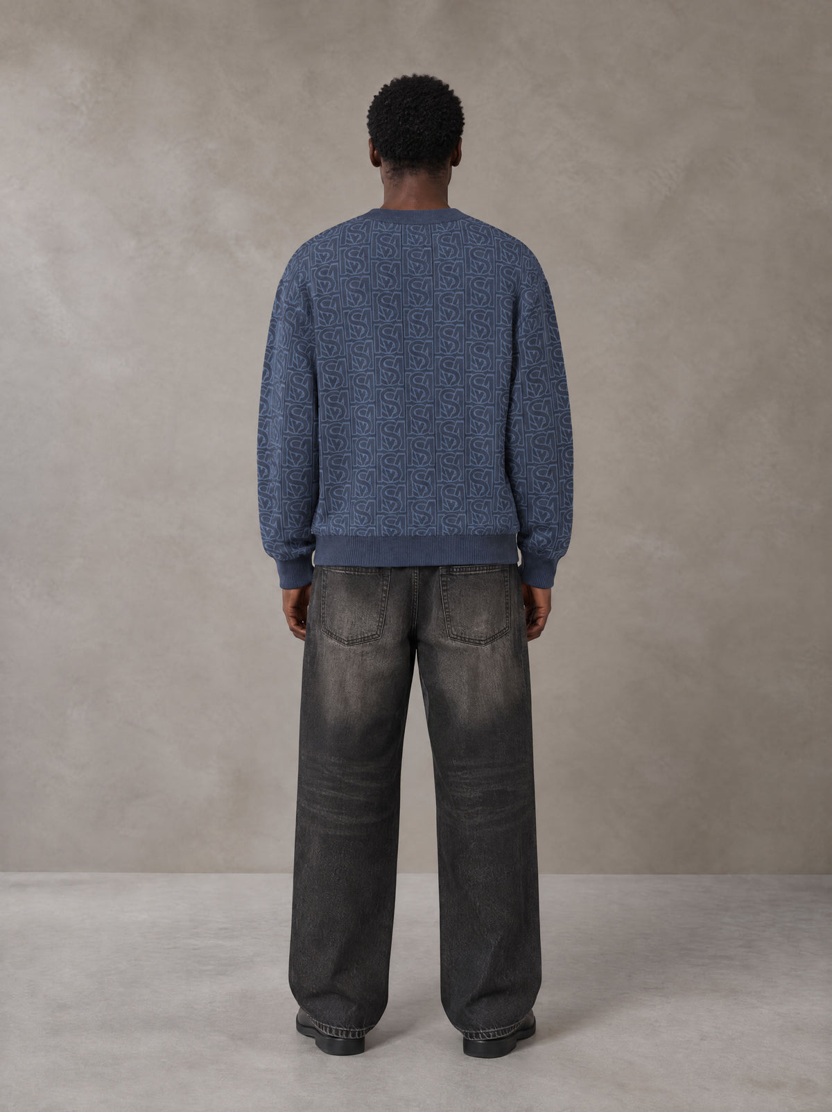 Model wearing the SM Jacquard Knitted Sweatshirt in Chambray, rear view.