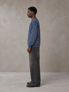 Model wearing the SM Jacquard Knitted Sweatshirt in Chambray, side profile.